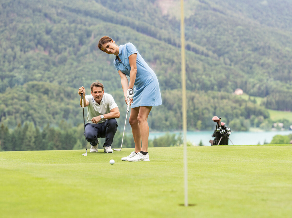 Pärchen beim Golfspielen auf dem hoteleigenen Golfplatz des Golfhotel Ebner's Waldhof am Fuschlsee.
