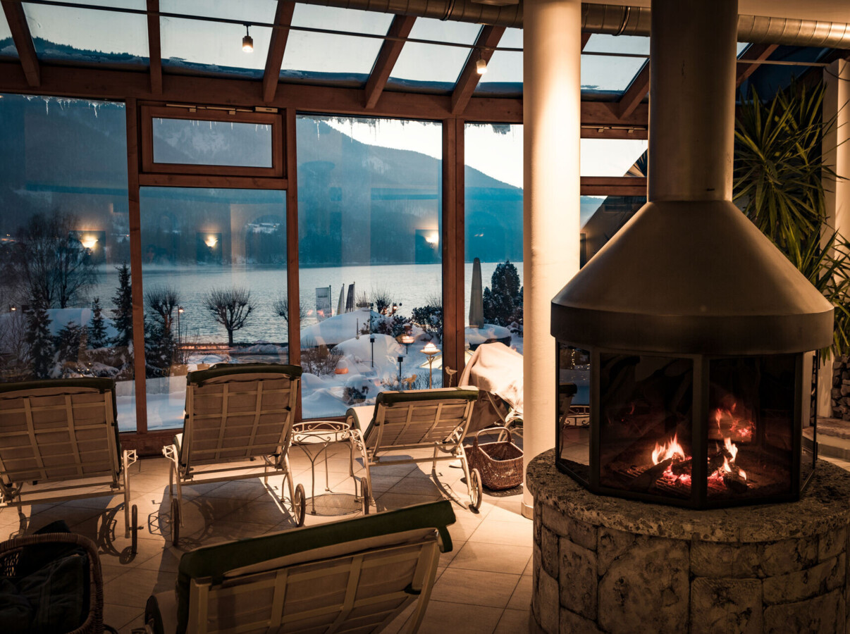 Der Ruheraum mit Panoramablick auf den winterlichen Fuschlsee im Wellnesshotel Ebner's Waldhof am See.